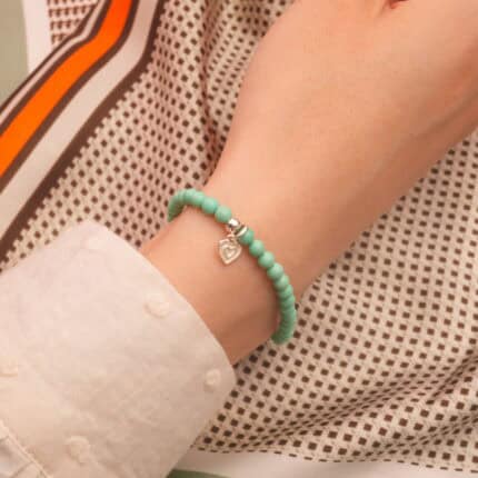 Wearing turquoise and agate bracelet with heart charm, casual look