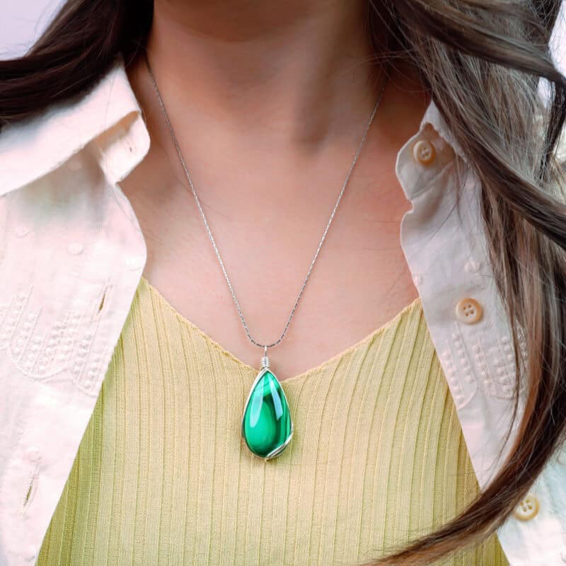 Model wearing the necklace, showing teardrop pendant resting at the chest