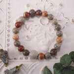 Men's Landscape Stone Beaded Bracelet placed next to leaves, highlighting natural energy and earthy design