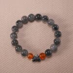 Gray rutile agate and rutile quartz 10mm protection bracelet with silver clasp on neutral background.