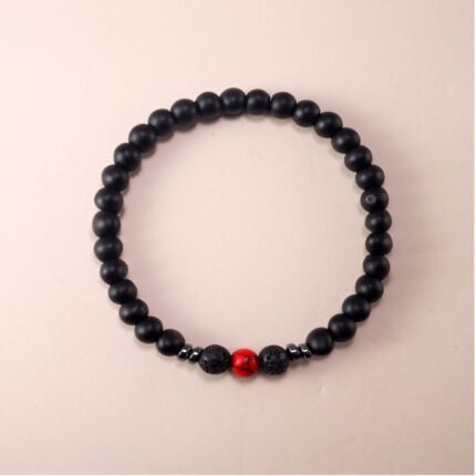 Matte black obsidian and red turquoise protection bracelet on white background