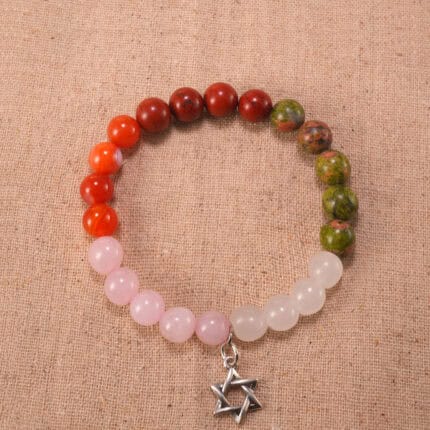 Rose quartz, red jasper, and agate bracelet with silver charm on a white background