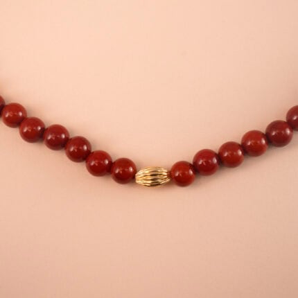 Close-up of polished red agate/carnelian round beads and knotting or clasp detail