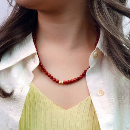 Model wearing the bead necklace, showing full length and warm color tones