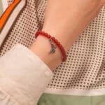 Woman wearing 4mm red agate butterfly charm bracelet – elegant and symbolic gemstone jewelry