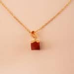 Close-up of polished red jasper crystal in pendant form with metal clasp