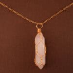 Close-up of the polished rose quartz point wrapped or capped in gold