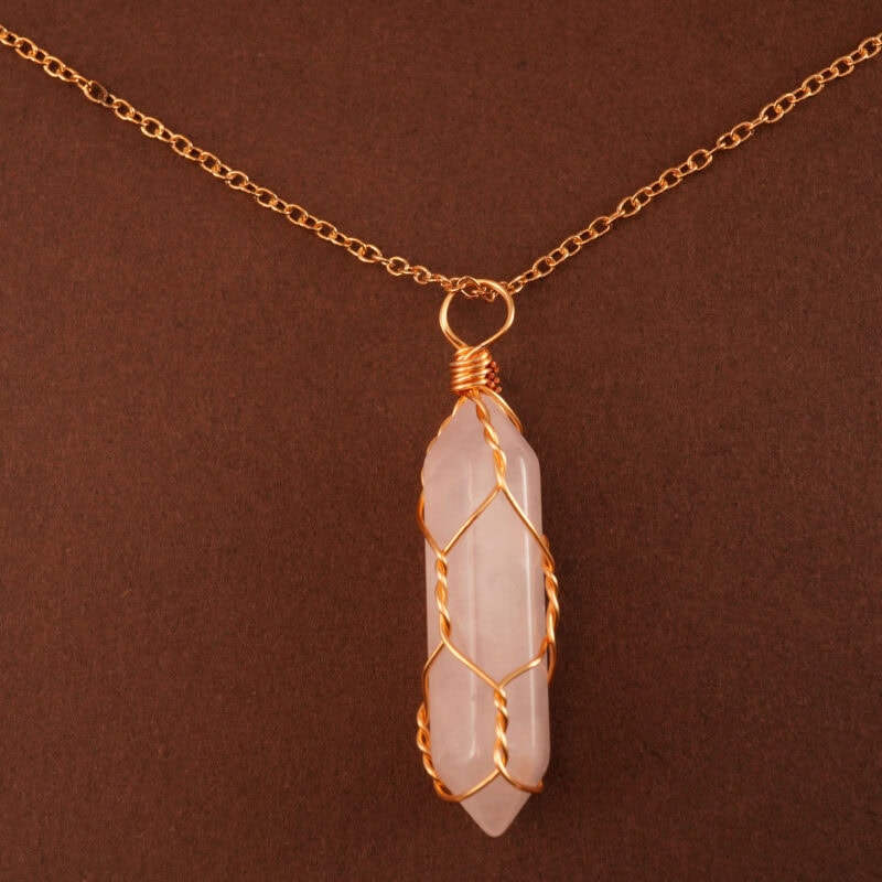 Close-up of the polished rose quartz point wrapped or capped in gold