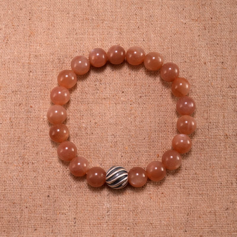 Peach moonstone bracelet with polished 6mm beads on a soft white background