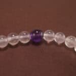 Close-up of the amethyst beads and finely crafted silver charm, highlighting the polished surface