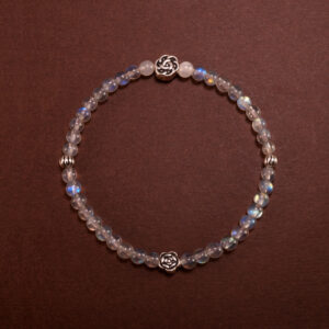 A dainty 4mm Moonstone bracelet styled on a soft-toned neutral background