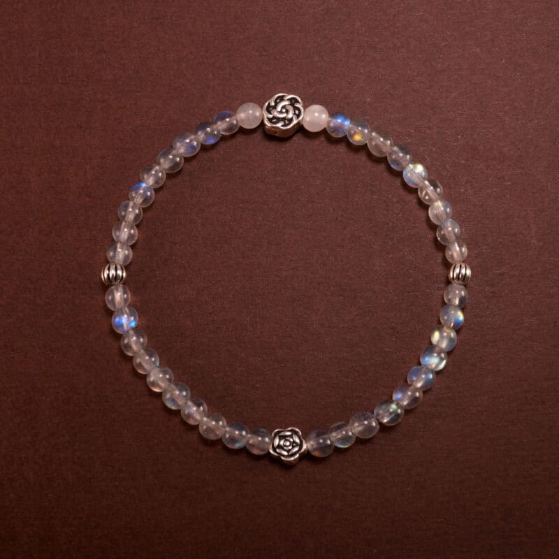 A dainty 4mm Moonstone bracelet styled on a soft-toned neutral background