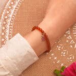 Garnet bracelet with star charm worn on wrist with a casual outfit