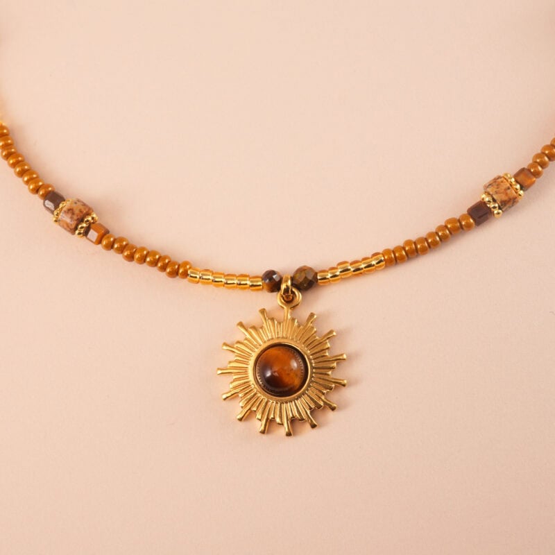 Close-up of tiger eye beads and sunflower charm detailing on necklace