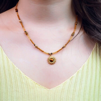Model wearing tiger eye sunflower bead necklace, showing pendant on collarbone