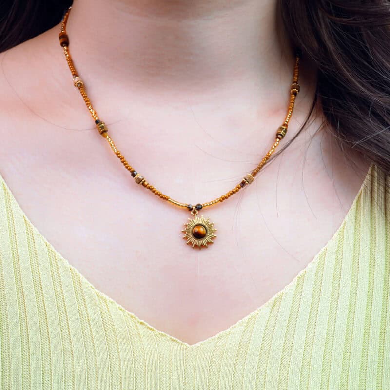 Model wearing tiger eye sunflower bead necklace, showing pendant on collarbone