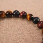 Close-up of heart charm and polished Tiger Eye beads