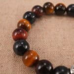 Close-up of heart charm and polished Tiger Eye beads