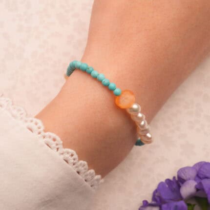 Woman wearing turquoise and pearl bracelet on wrist