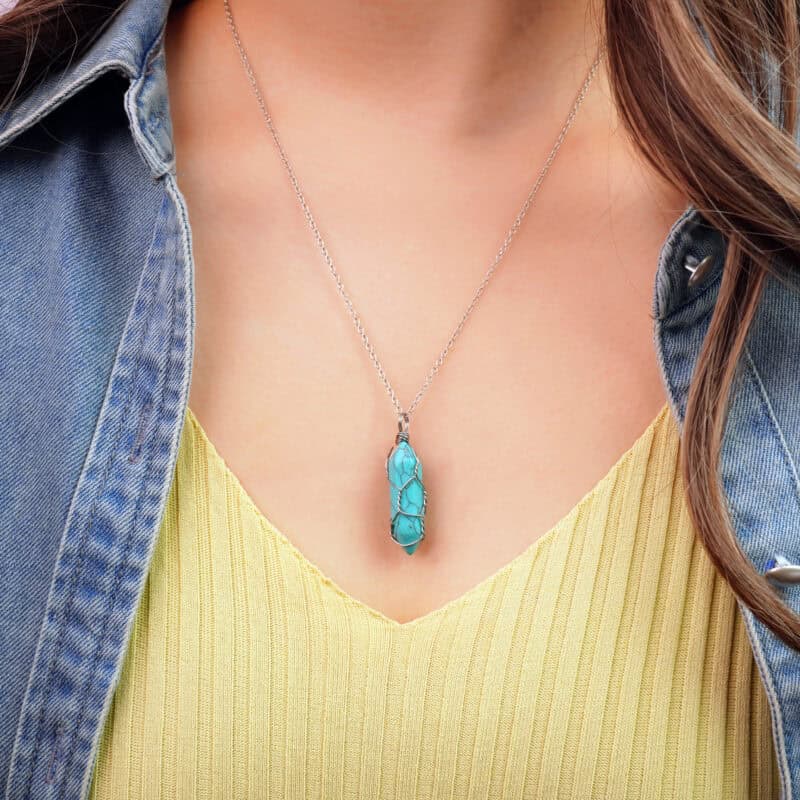 Model wearing the turquoise point pendant at collarbone or heart level