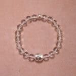 Clear quartz 8mm bracelet with silver accents on white background