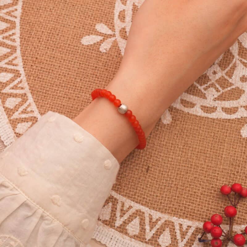 Woman wearing 4mm carnelian bracelet – sleek, energizing, handcrafted jewelry