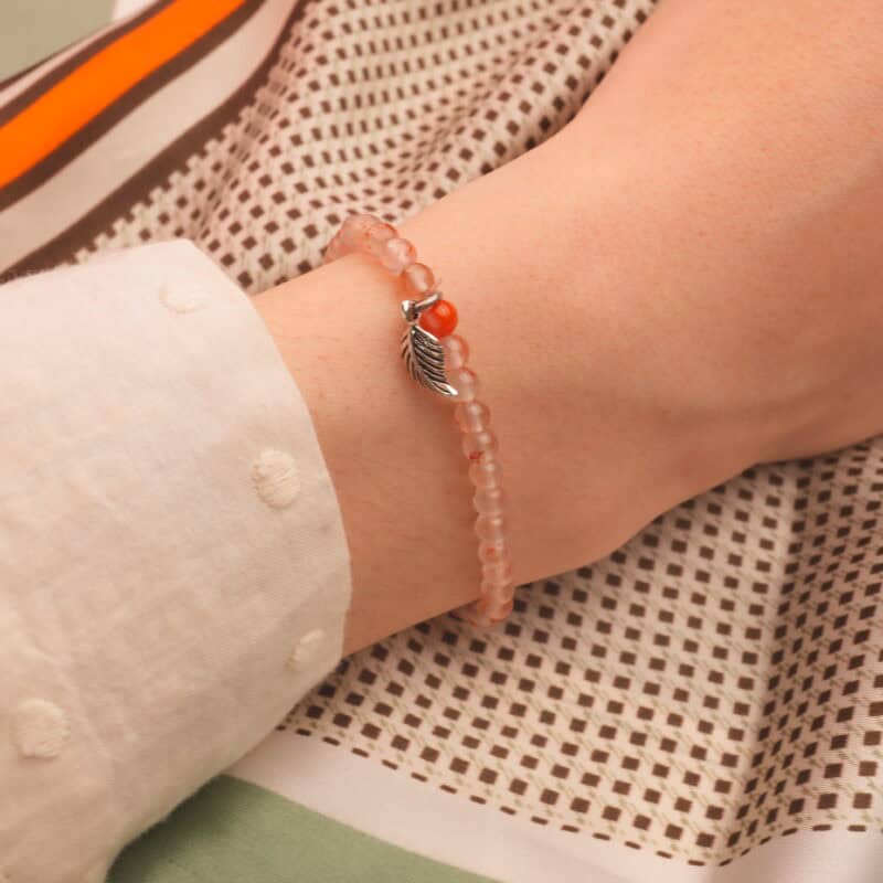 4mm chalcedony bracelet with silver charm worn on wrist in minimalist daily style