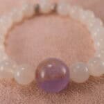 Close-up of polished white agate and amethyst beads with sterling silver clasp