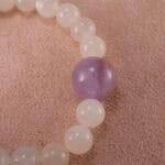 Close-up of polished white agate and amethyst beads with sterling silver clasp