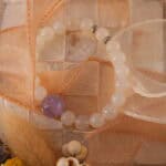 White agate and amethyst bracelet styled with natural elements and soft lighting