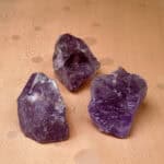 Natural Amethyst raw stone set arranged neatly on a light background, featuring rich purple tones and raw crystal textures.