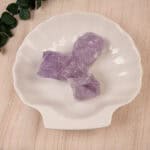 Amethyst stones placed in a cozy setting with candles and plants, adding a peaceful and healing vibe.