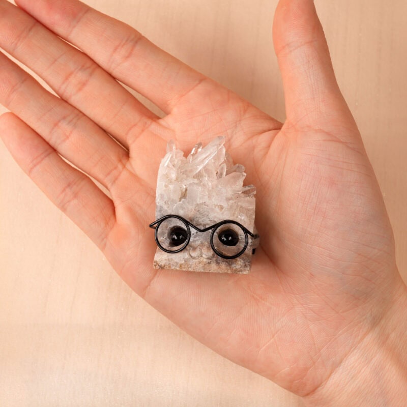 Person holding Clear Quartz hedgehog figurine in palm, showing crystal texture and size