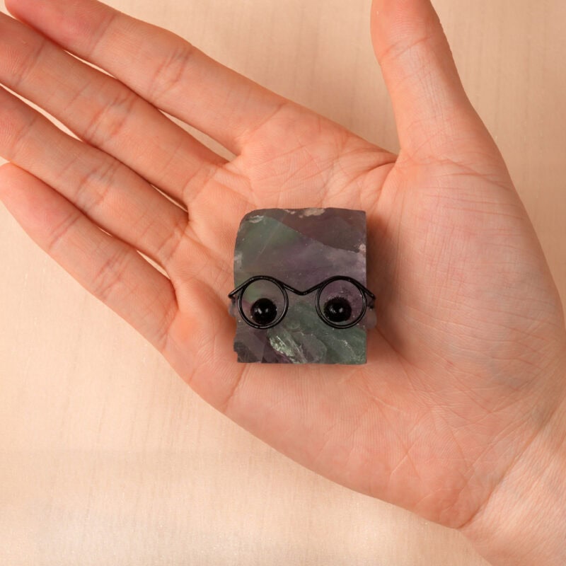 Hand holding Fluorite hedgehog figurine, showing color gradient and small size