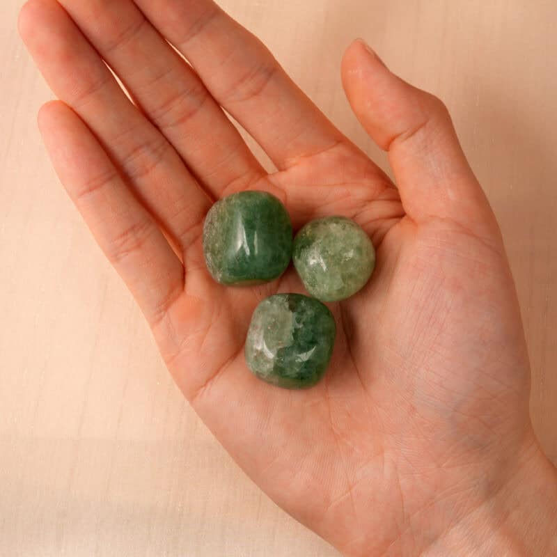 Hand holding a Green Strawberry Quartz Tumbled Stone for emotional healing