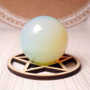 Polished opal crystal sphere with pastel glow on clean background