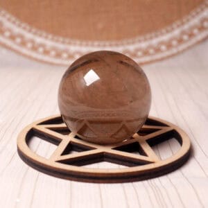Polished Smoky Quartz sphere with translucent brown tones on display stand