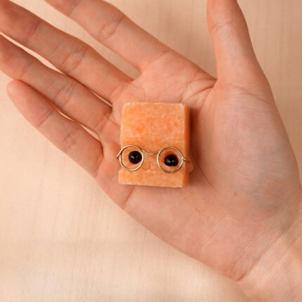 Person holding a small Sunstone hedgehog figurine in palm, showing size and texture