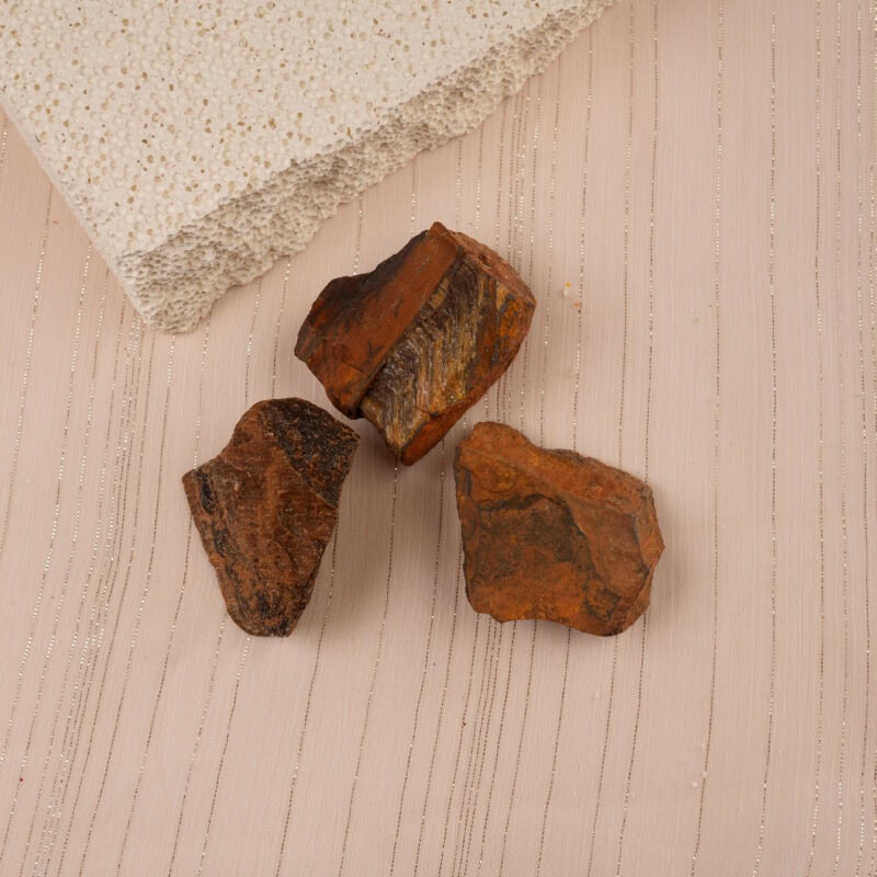 Tiger Eye stones placed in a calming setup with books and natural decor, evoking grounding energy.