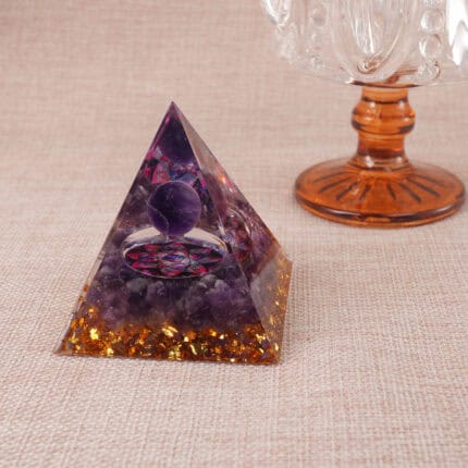 Decorative resin pyramid with amethyst and clear quartz placed in meditation setting