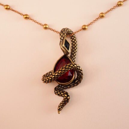 Close-up of serpent detail coiling around a faceted or cabochon ruby