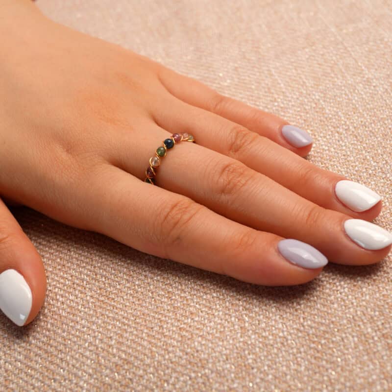 Hand wearing the Tourmaline Woven Ring, showcasing its vibrant tourmaline gemstones and woven band design