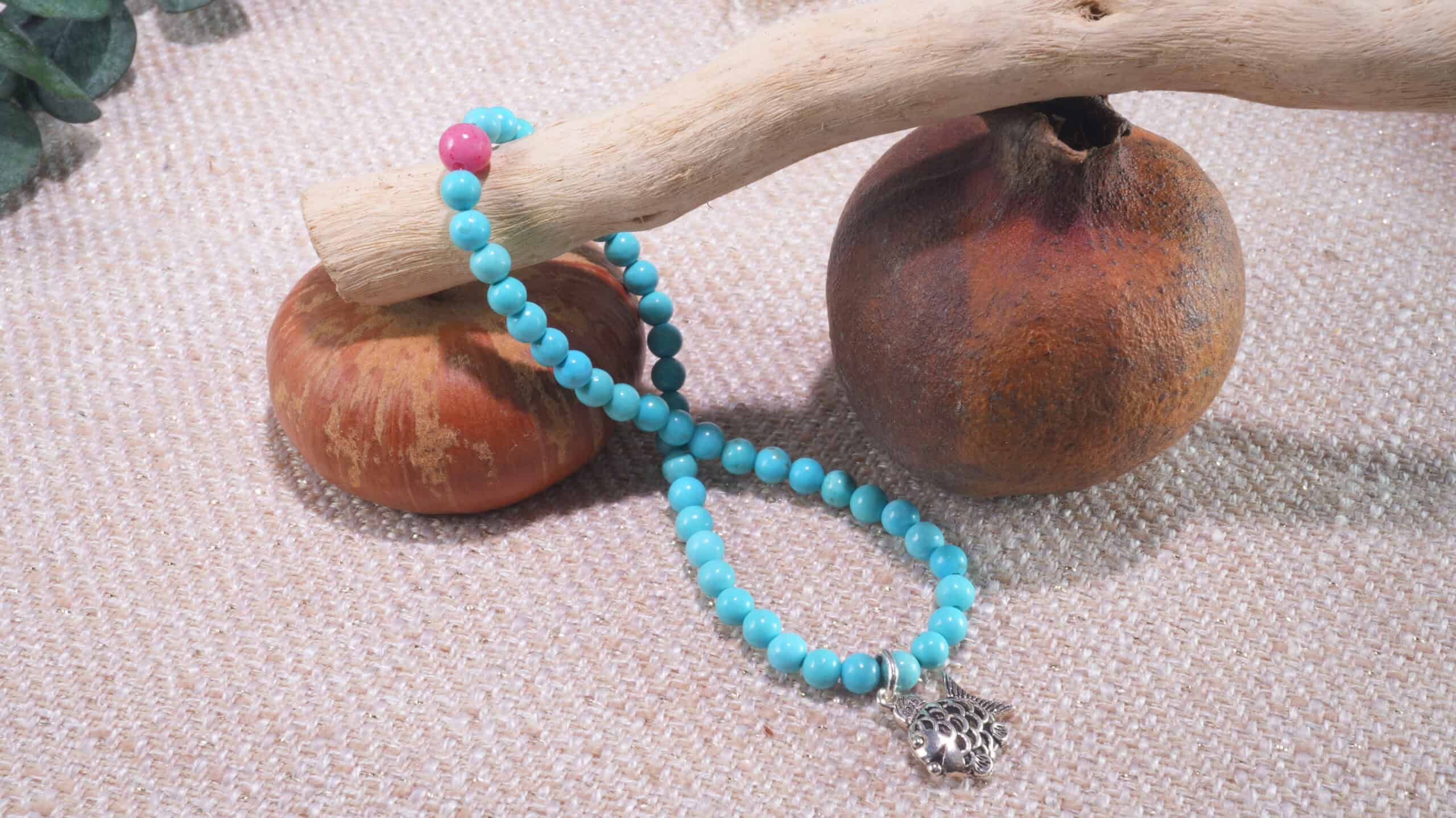 Turquoise crystal bracelet resting on a tree branch, natural gemstone jewelry photography