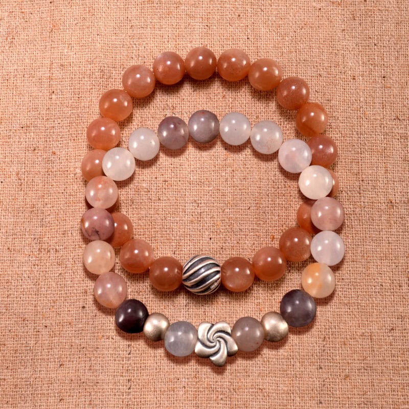 Main image showing stacked peach moonstone and aventurine S925 bracelets.