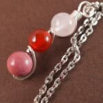 Close-up of Cancer necklace showing clear quartz, red agate, and rhodochrosite beads.