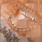 Clear quartz bracelet in natural light with a soft reflective glow.