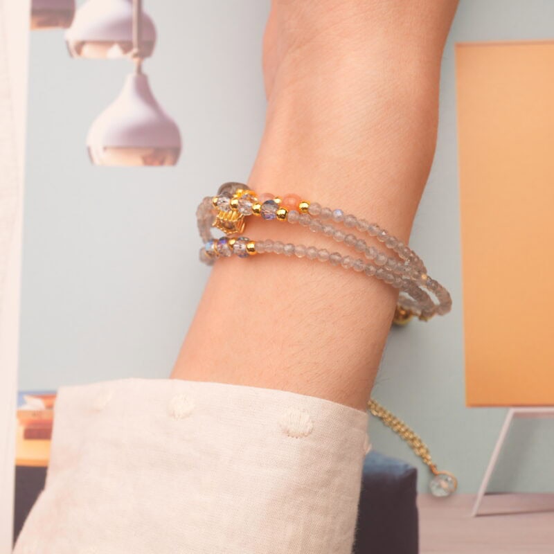 Model wearing the piece wrapped around the wrist, highlighting the cool-toned stones and delicate texture.