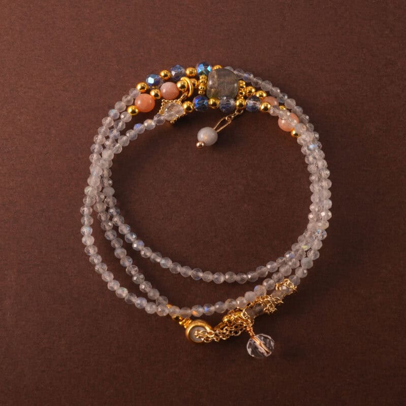 Multi-use bracelet-necklace made of gray moonstone and clear quartz, styled in a three-wrap design.
