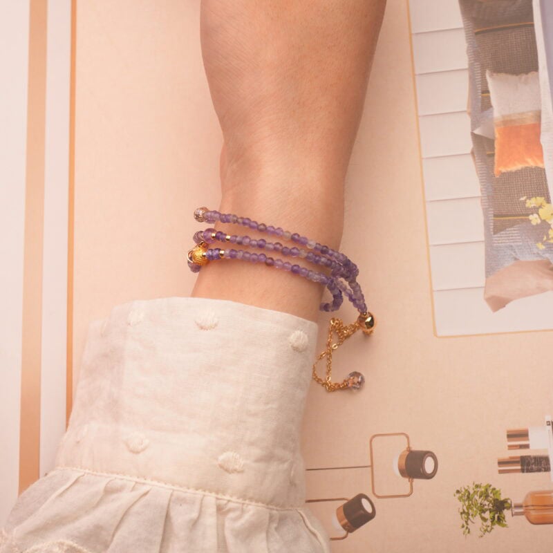 Model wearing the amethyst bracelet wrapped around the wrist, showing its elegant and spiritual charm.
