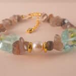 Close-up of the intricate textures in the skeleton quartz bead, beside polished pearl and aquamarine accents.